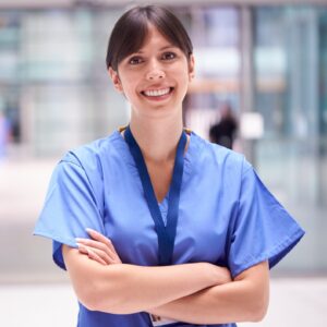Nurse standing in hall with smile.
