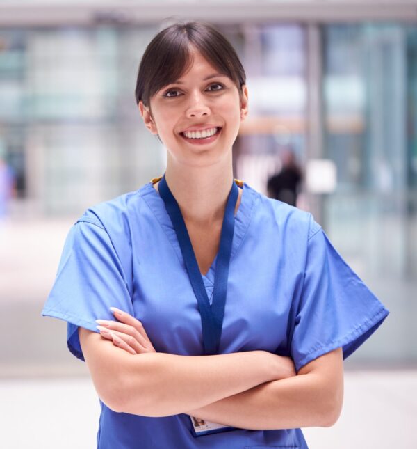 Nurse standing in hall with smile.