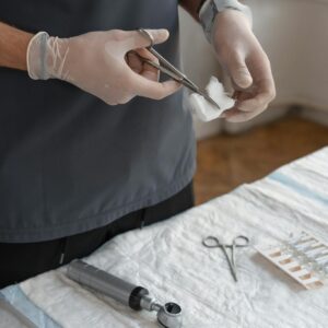 Healthcare worker using scissors to cut gauze for medical procedure.