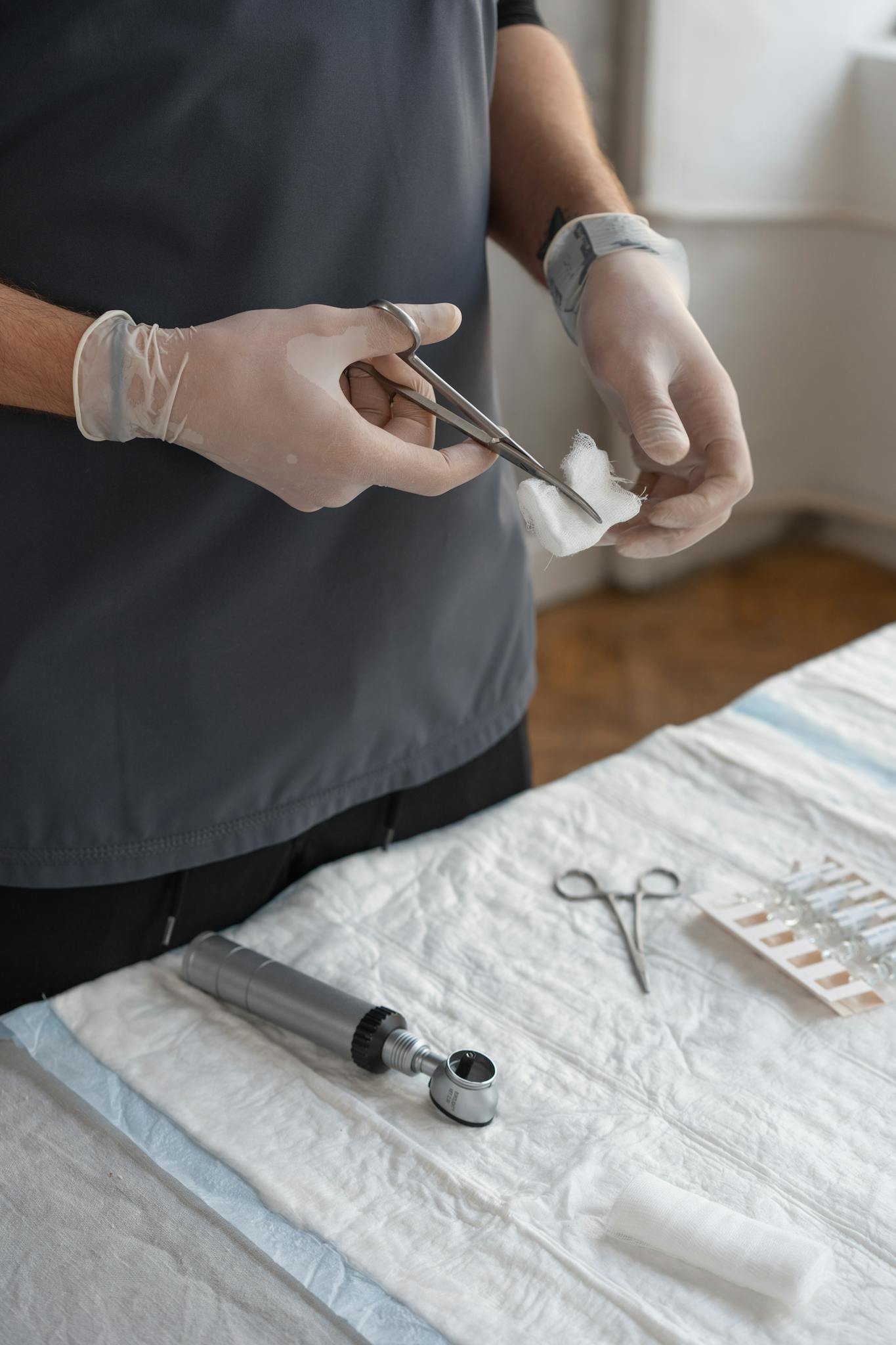 Healthcare worker using scissors to cut gauze for medical procedure.